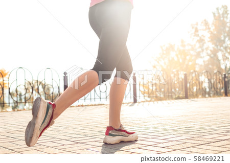 Healthy Lifestyle. Young woman jogging outdoors autumn season feet close-up 58469221