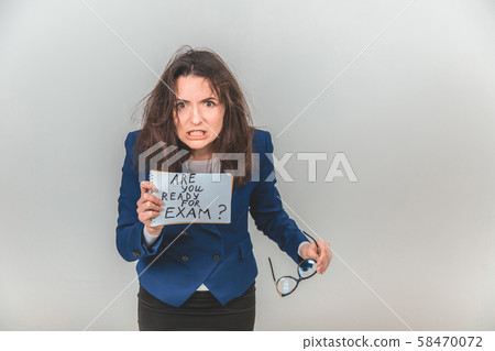 Totally tired young teacher is standing, holding a sheet of paper with ready for exam written on it 58470072