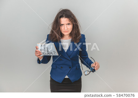 Totally tired young teacher is standing, holding a sheet of paper with ready for exam written on it Totally tired young teacher is standing, holding a sheet of paper with ready for exam written on it 58470076