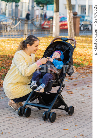 A woman with a child in a stroller walks through A woman with a child in a stroller walks through 58470528