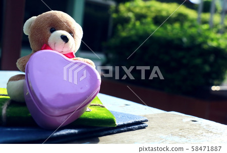 Teddy bear sitting notebook on green back ground copy space. 58471887