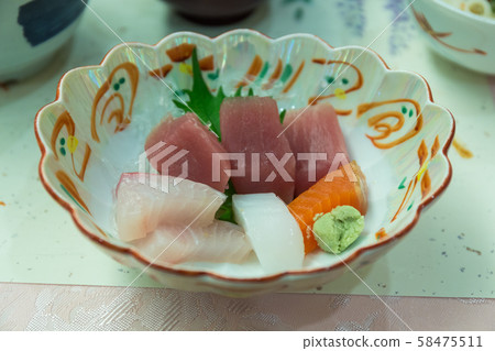 Salmon or Tuna Sashimi on Japanese dish with vegetables and flowers with wasabi on table. Salmon or Tuna Sashimi on Japanese dish with vegetables and flowers with wasabi on table. 58475511