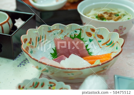 Salmon or Tuna Sashimi on Japanese dish with vegetables and flowers with wasabi on table. Salmon or Tuna Sashimi on Japanese dish with vegetables and flowers with wasabi on table. 58475512