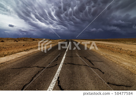 Dramatic thunderstorm sky over an old empty road Dramatic thunderstorm sky over an old empty road 58477584