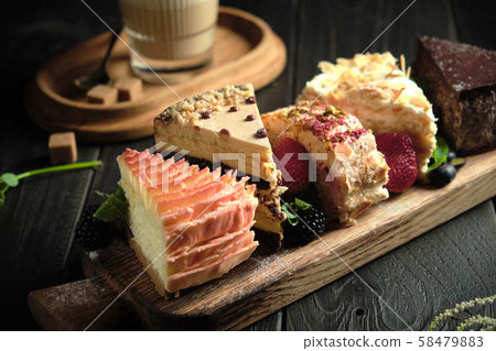 Different pieces of cakes on a wooden board . catering menu 58479883