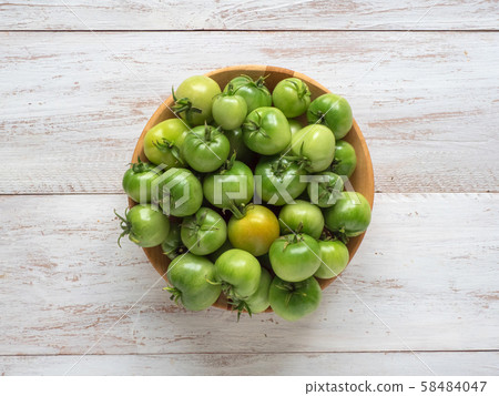 Green unripe tomatoes in a bowl. Green unripe tomatoes in a bowl. 58484047