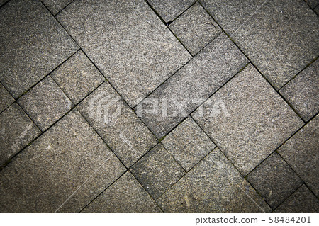The sidewalk road made of natural stone is lined with mosaics of light gray color .Texture 58484201