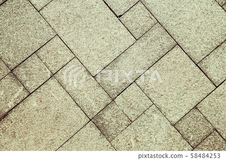 The sidewalk road made of natural stone is lined with mosaics of light gray color .Background. The sidewalk road made of natural stone is lined with mosaics of light gray color .Background. 58484253