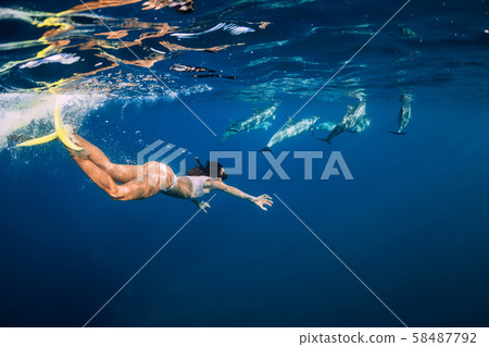 Young woman swim underwater with dolphins in blue ocean. Mauritius 58487792