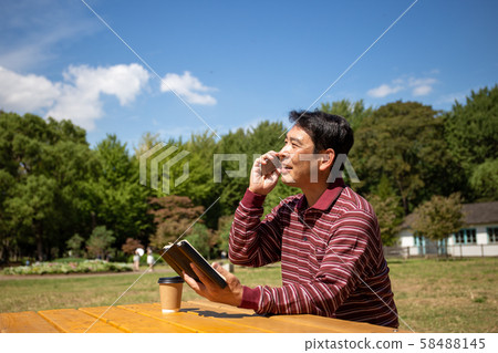 遠程辦公在一個陽光明媚的公園裡休息 58488145