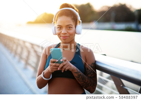 Dark-eyed woman using sport app before starting morning run 58488397