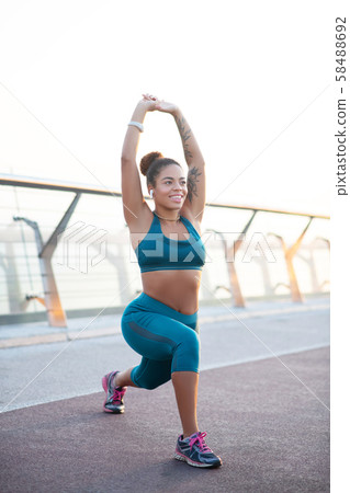Beaming young woman doing morning yoga outside Beaming young woman doing morning yoga outside 58488692