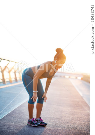 Woman making little break while running in the morning Woman making little break while running in the morning 58488742