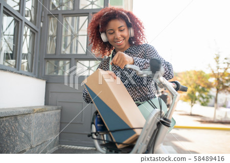 Curly girl before opening her parcel with cosmetics 58489416