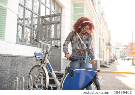 Student typing message for friend after riding bike Student typing message for friend after riding bike 58489468