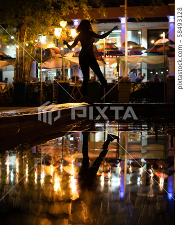 Bokeh backlight girl silhouette after rain on the street at night 58493128