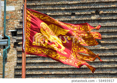Flag of Venice waving on street in Venice, Italy. 58493917