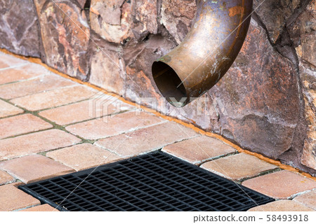 Gutter downspout on the wall of house 58493918