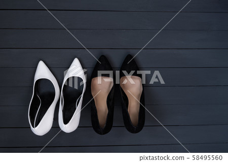 Black and white female shoes on a black wooden Black and white female shoes on a black wooden 58495560