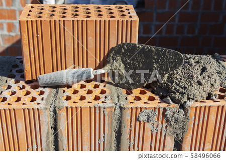 Spatula and cement mortar, red brick masonry Spatula and cement mortar, red brick masonry 58496066