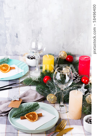 Festive Christmas and New Year table setting with dry orange and cinnamon on a gray textile. Dining 58496400