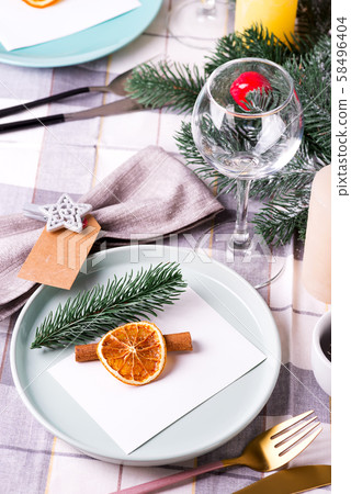 Festive Christmas and New Year table setting with dry orange and cinnamon on a gray textile. Dining Festive Christmas and New Year table setting with dry orange and cinnamon on a gray textile. Dining 58496404