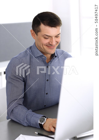 Businessman working with computer in modern office. Headshot of male entrepreneur or company 58497417