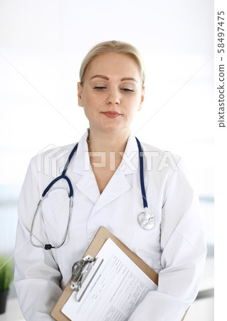 Doctor woman adult standing straight in hospital office, portrait. Perfect medical service in clinic Doctor woman adult standing straight in hospital office, portrait. Perfect medical service in clinic 58497475