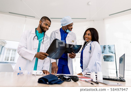 radiology, people and medicine concept - group of three African doctors, surgeon and radiologists radiology, people and medicine concept - group of three African doctors, surgeon and radiologists 58497947