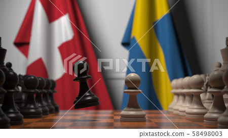 Flags of Switzerland and Sweden behind pawns on the chessboard. Chess game or political rivalry 58498003