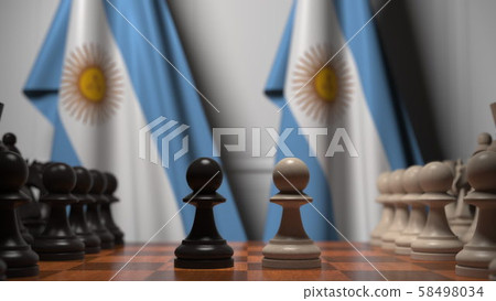 Flags of Argentina behind pawns on the chessboard. Chess game or political rivalry related 3D 58498034