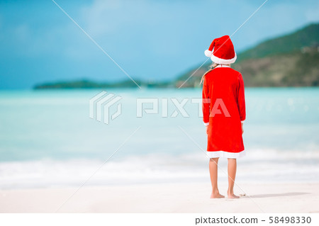 Adorable little girl in Santa hat on tropical beach Adorable little girl in Santa hat on tropical beach 58498330