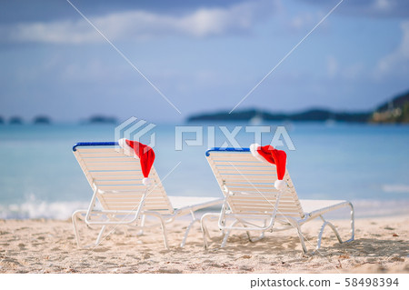 Closeup santa hat on chair on tropical white beach Closeup santa hat on chair on tropical white beach 58498394