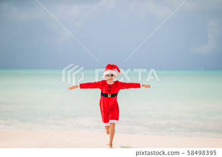 Adorable little girl in Santa hat on tropical beach Adorable little girl in Santa hat on tropical beach 58498395