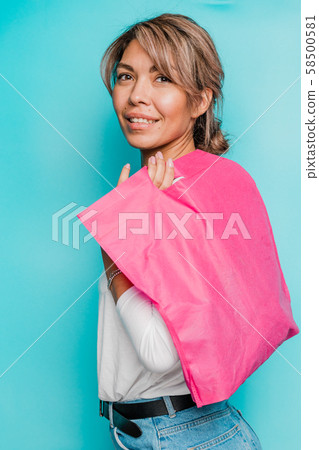 Young smiling woman in casualwear holding bright pink textile bag on shoulder 58500581