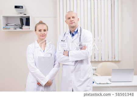 Two confident colleagues in medical uniform standing close to each other 58501348