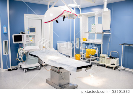 Operation table with large lamps above inside contemporary surgery room 58501883