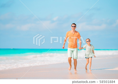 Little girl and happy dad having fun during beach vacation 58501884