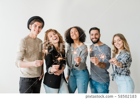 Ecstatic guys and girls with bengal lights enjoying new year home party 58502183