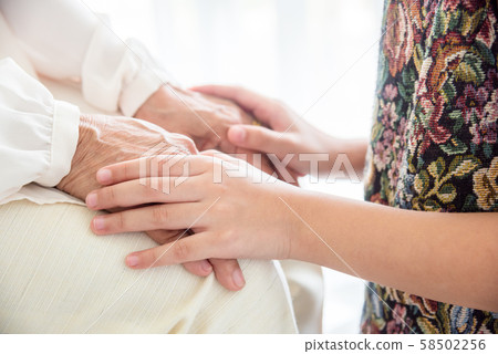 Close up of young girl holding senior hands Close up of young girl holding senior hands 58502256