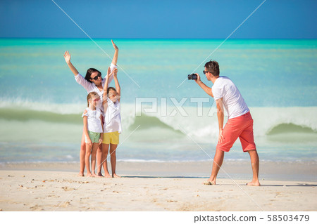 Family of four taking a selfie photo on their beach holidays. Family beach vacation 58503479