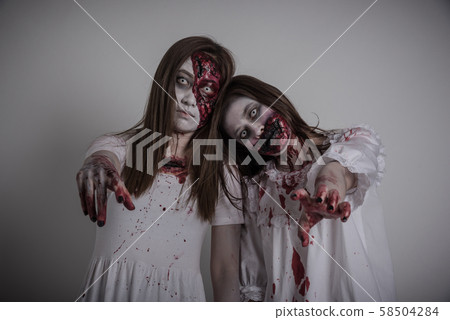 Scary two asian female zombie standing over gray and dark background Scary two asian female zombie standing over gray and dark background 58504284