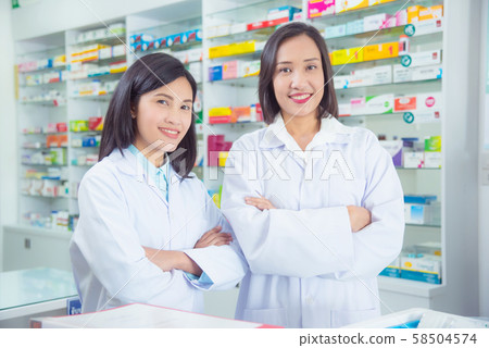 Two asian female pharmacist standing and smiling in pharmacy  58504574