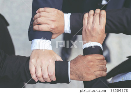 Close up of Group people of businessmen joining putting their Close up of Group people of businessmen joining putting their 58504578