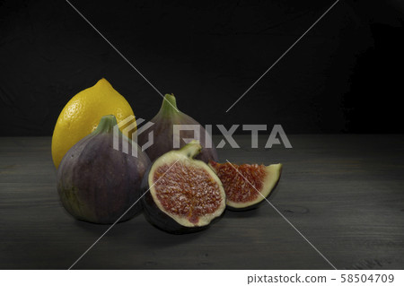 Whole lemon, figs and one sliced on wooden table Whole lemon, figs and one sliced on wooden table 58504709