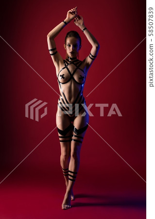 Nude brunette with black tape bodyart shot Nude brunette with black tape bodyart shot 58507839
