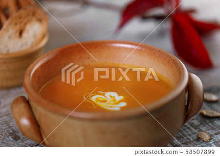 Pumpkin cream soup in a ceramic dish 58507899