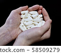 Female hand holding a large amount of medicine 58509279