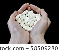 Female hand holding a large amount of medicine 58509280