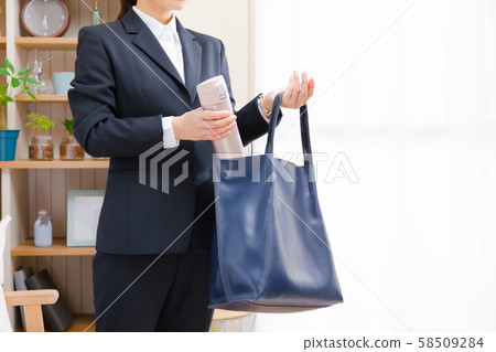 Business woman putting a water bottle in a cage at home Business woman putting a water bottle in a cage at home 58509284